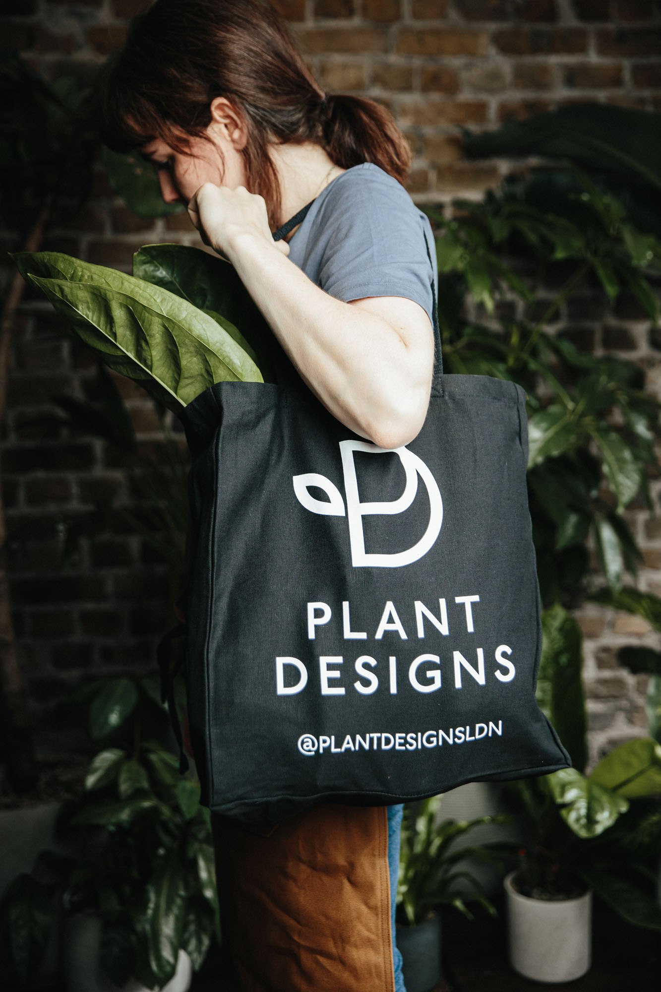 person holding bag with plant